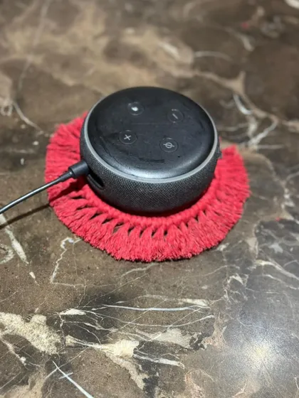 My coasters are versatile. Here, a red one serves as a stylish little mat for an Amazon Echo Dot, preventing scratches and adding a touch of decor.