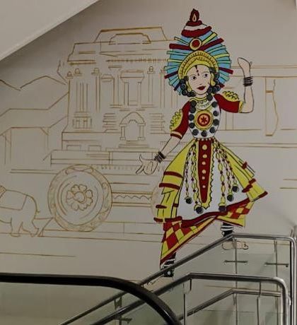 Another piece from the Shopper's Stop project, this one featuring a colorful depiction of a traditional Karnataka folk dancer against a line-art background of Hampi.