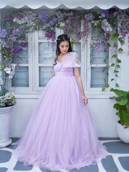 Introducing 'Gorgina', a beautiful lilac gown. It features a detachable belt to cinch the waist and a unique, structured sleeve detail for a touch of modern sophistication.