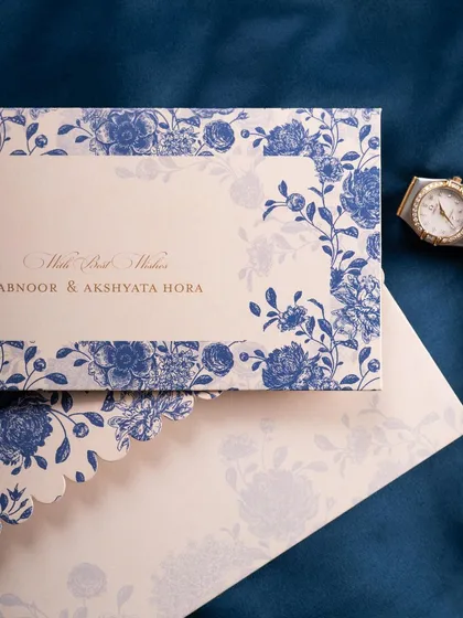 A classic flat lay of a blue floral wedding invitation and envelope. The simple, elegant composition on a dark background is timeless and effective.