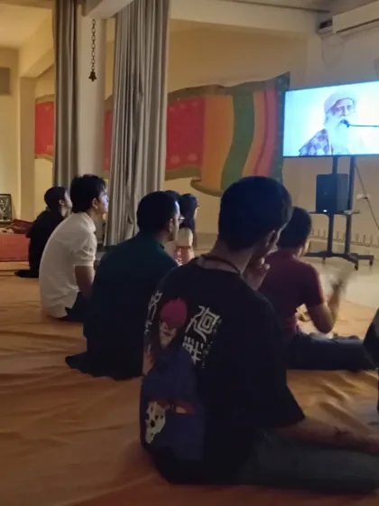 The community watching a discourse by Sadhguru. These sessions are an integral part of our gatherings, offering clarity and inspiration on the spiritual path.
