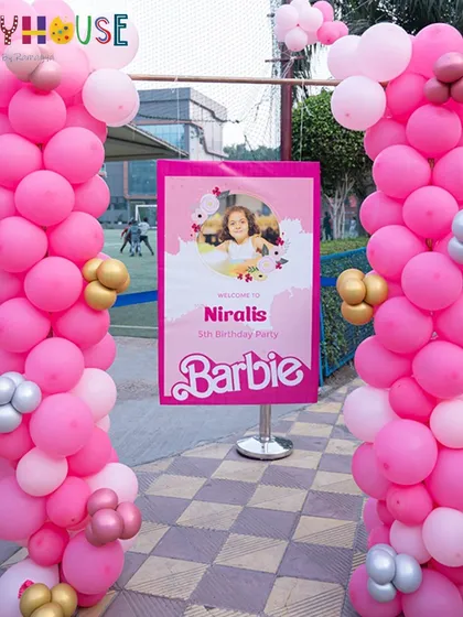 The entrance to Nirali's Barbie party, with a grand pink balloon display and a custom welcome sign.