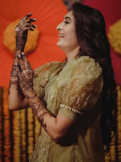 The best part of my job is seeing a happy client. Here is a beautiful moment from a mehndi function, where she is joyfully admiring her full-hand henna. It is an honor to be a part of your special days.