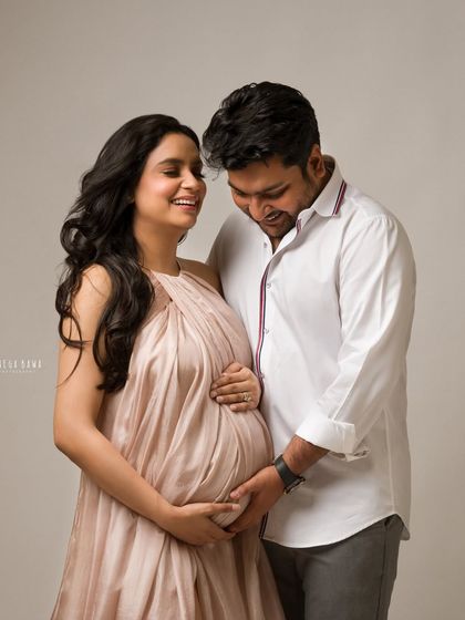 A shared laugh between an expecting couple. This candid moment shows the joy and love they share as they look forward to becoming parents.