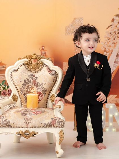 A dapper little gentleman. A classic black suit is a timeless choice for a first birthday or any special milestone.
