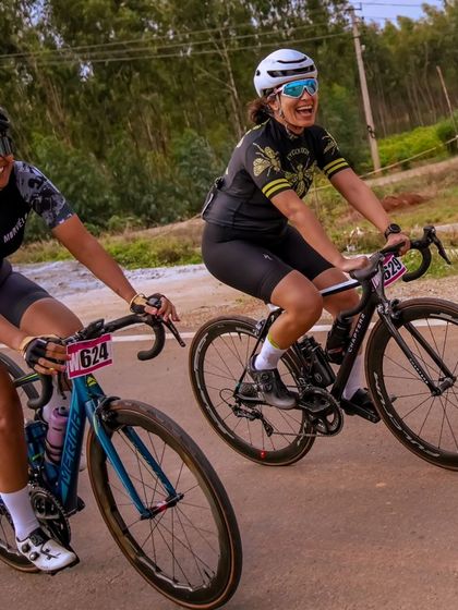 Two female riders, smiling and enjoying the race.