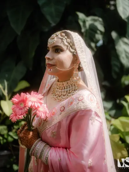 A classic bridal portrait of Archana in her beautiful pink lehenga. The soft, natural light and her serene expression make for a timeless and elegant image.