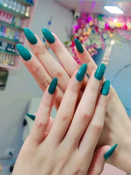Another view of the stunning solid teal green nails, showcasing the perfect shape and glossy finish.