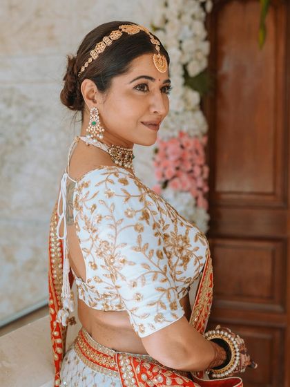 A classic three-quarter portrait of the bride, showcasing the elegant back of her blouse and her traditional hairstyle.