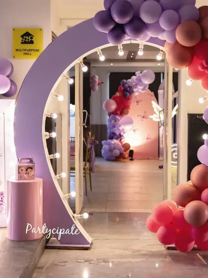 Creating a grand entrance is key. For this butterfly-themed party, I used a lighted archway with a cascading balloon garland and a personalized welcome sign to make guests feel like they were entering a special world.