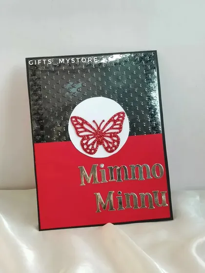A custom card with the couple's nicknames, "Mimmo" and "Minnu," part of a special engagement anniversary hamper.