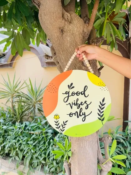 Our 'Good Vibes Only' wooden sign hanging on a tree. The vibrant colors and positive message make this a perfect piece to add a cheerful touch to your home or garden.