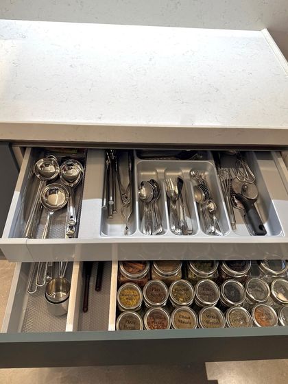 A layered drawer system with cutlery on top and spices below. This is a fantastic solution for compact kitchens, maximizing storage in a single space.