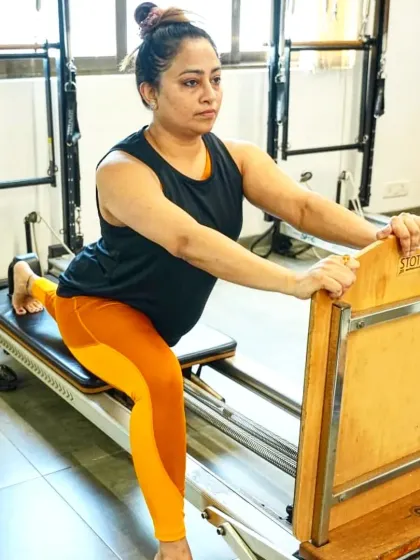 Consistency is the secret to results. This client demonstrates a controlled lunge on the reformer, a testament to her daily commitment to moving her body and building strength.