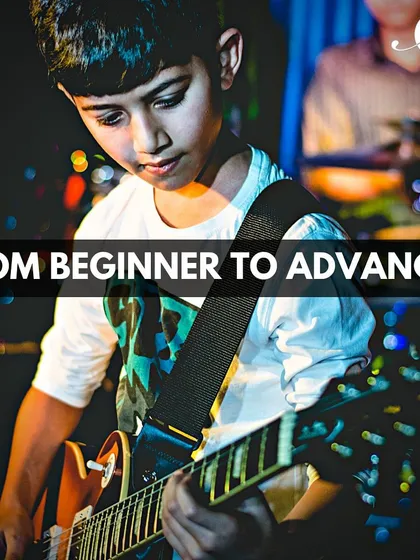 This image shows a young student progressing on his guitar journey. Our courses are structured to take players from beginner to advanced levels, covering technique, theory, and performance.