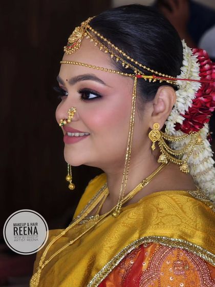 A side profile of Shivangi, showcasing her intricate floral bun with red and white flowers and her traditional Maharashtrian head jewellery.