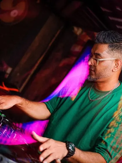 A side profile of me focused on the mixer during my set in Siliguri, with colorful light trails adding to the atmosphere.