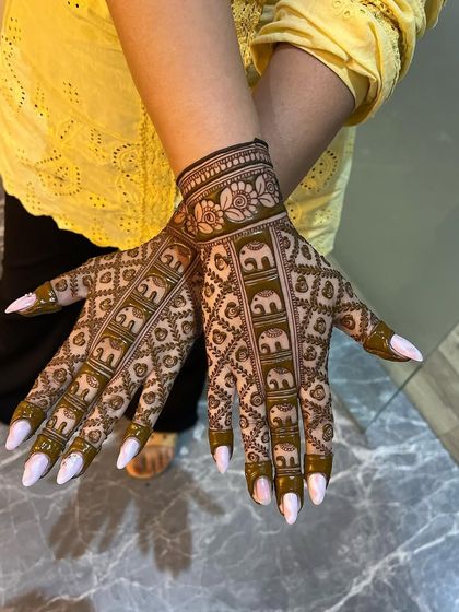 This is a very popular design featuring rows of elephants marching up the fingers. The intricate jaali (net) pattern fills the rest of the hand, creating a dense and traditional look that is perfect for brides.
