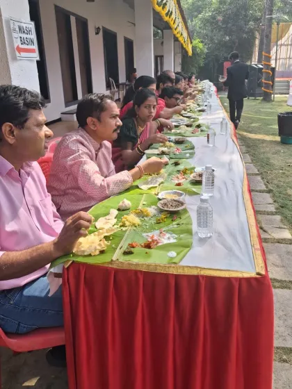 For those who want a truly traditional experience, we offer pangat style dining. Here you can see guests enjoying a meal served on banana leaves at a wedding event in Uran.