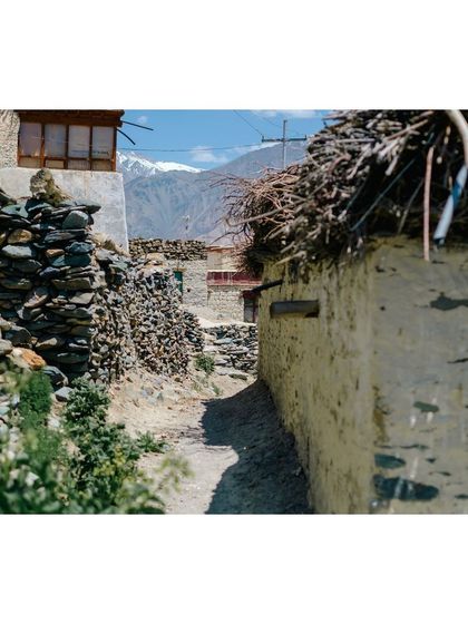 A narrow, rustic alleyway within Karsha village, showing the traditional stone and mud-brick architecture.