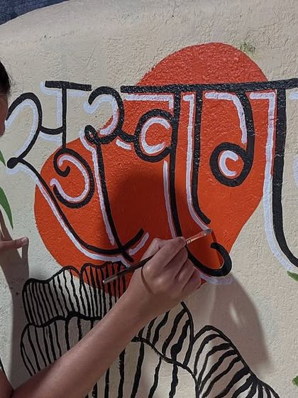 The process of creating the 'Suswagatam' mural, focusing on the precise brushwork required for the Marathi calligraphy.