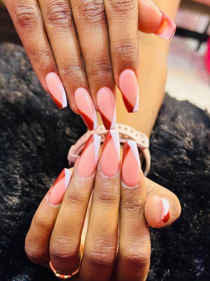 A bold and graphic French tip. I used a long coffin nail shape and created a sharp chevron V-tip design, combining a crisp white line with a deep red color for high contrast.