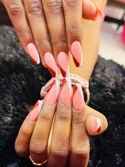 A bold and graphic French tip. I used a long coffin nail shape and created a sharp chevron V-tip design, combining a crisp white line with a deep red color for high contrast.
