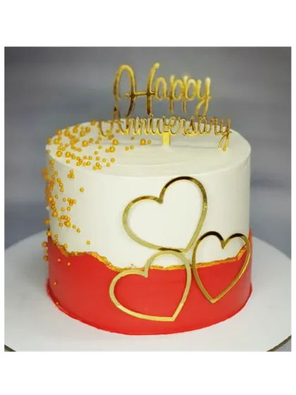 Another take on a modern anniversary cake design. This chocolate mousse cake features a red and white color scheme with elegant golden heart accents.