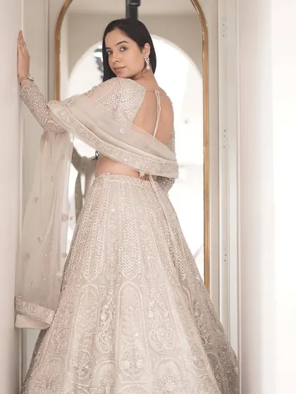 The back of this stunning white lehenga, showing off the beautiful open-back design and detailed embroidery.