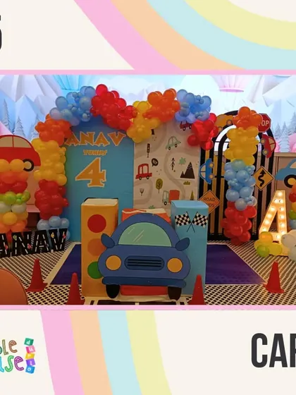 Our Cars theme is ready for the racetrack with a road-themed floor, traffic cones, and a colorful balloon arch.