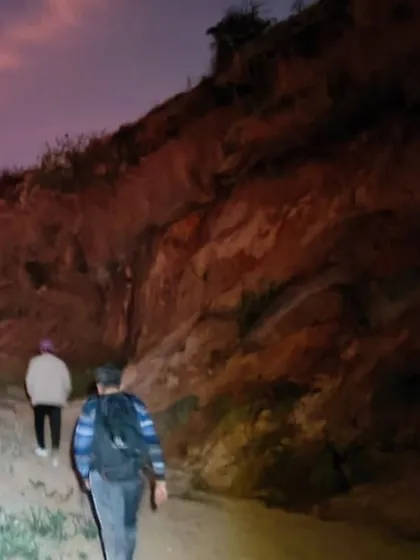 Trekkers making their way up a path in the early morning twilight.
