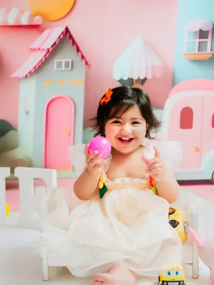 Another happy smile from the birthday girl. The detailed, custom-made background with pastel houses and cars makes these photos truly special.
