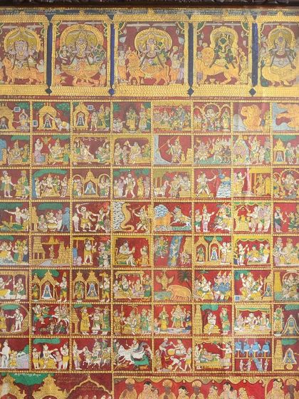 A stunning depiction of Lord Nataraja in a Tanjore painting. The cosmic dancer is shown alongside Ganesha, Murugan, and the divine Nayanar saints, set against a vivid red backdrop that highlights their significance.