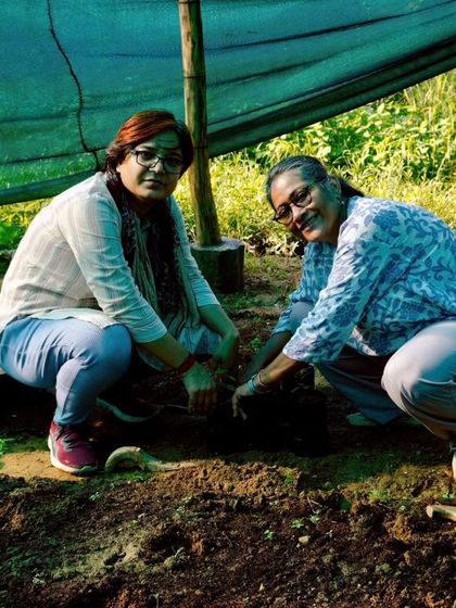 Two participants in our nursery workshop smile as they learn to transplant seedlings, getting hands-on experience in ecological restoration.
