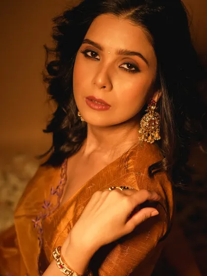 A direct and confident gaze. The eye makeup is defined but not overpowering, letting her natural beauty be the focus.