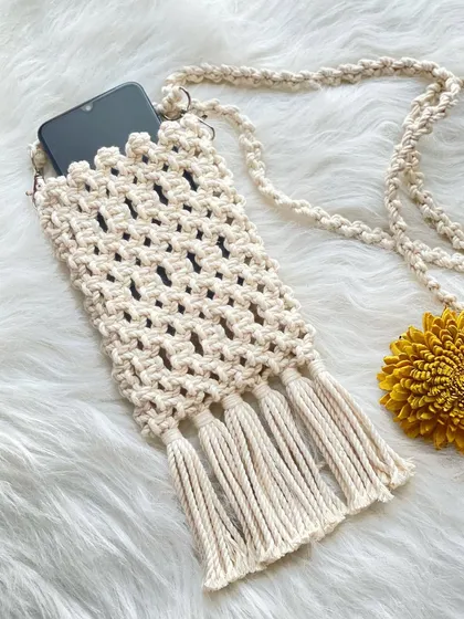 My macrame phone pouches are a customer favorite. This one, in a natural off-white cord, is perfect for keeping your phone handy on the go and features four delicate tassels for a touch of fringe.