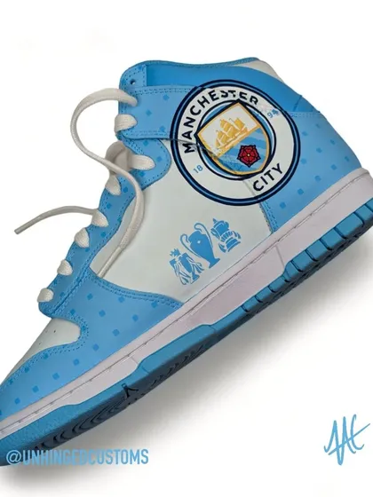A close-up of the current Manchester City crest, hand-painted with precision on the heel of the dunk.
