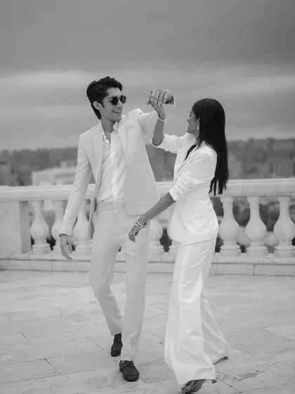 A candid black and white shot of the couple dancing on a balcony overlooking Baku. Their joyful, spontaneous movement is captured beautifully, creating a lively and authentic portrait.