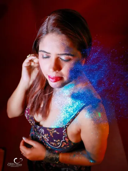 Capturing the dynamic movement of glitter being blown onto her. This shot is full of energy and a sense of transformation.