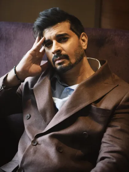 A close-up portrait of Tahir Raj Bhasin, looking directly at the camera. His expression is intense and engaging, drawing the viewer in.
