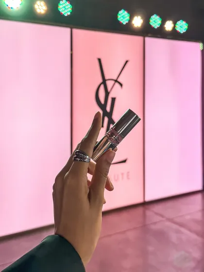 A close-up of a YSL lipstick against the event backdrop, perfect for social media buzz.