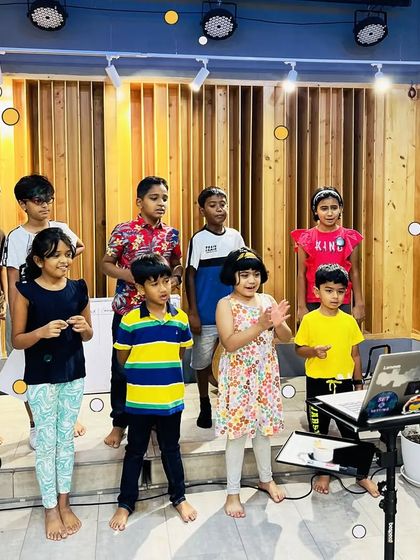 A vocal group practices with their instructor. Our camp includes group singing sessions to help kids learn about harmony and performance.