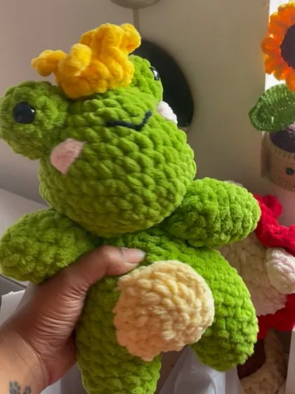 A close-up of the frog prince plushie, showing his sweet, sleepy expression. This soft and cuddly friend is ready for a new home.