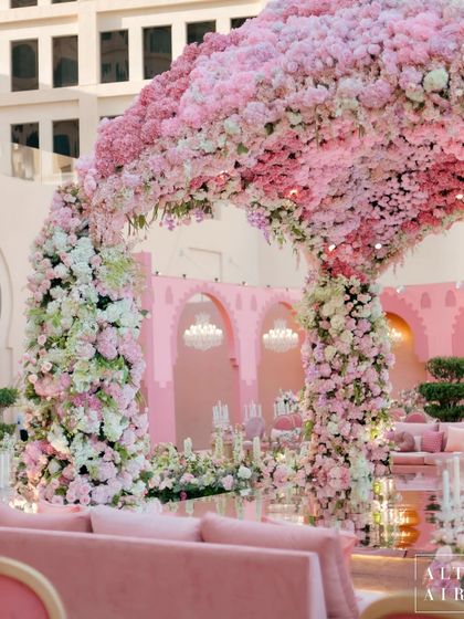 The 'Echoes of Pink' mandap seen from the guest seating area. The structure perfectly frames the view of the sea, creating a picturesque and romantic setting for the ceremony.