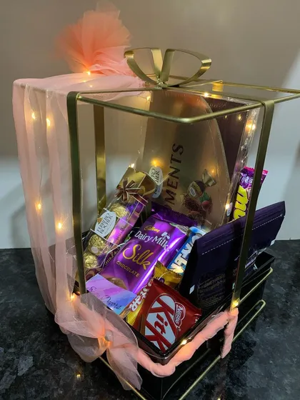 You can never go wrong with a classic chocolate hamper. This elegant metal bow basket is overflowing with a variety of favorites, including Ferrero Rocher, Cadbury Silk, and KitKat, making it an ideal gift for any celebration or just because.