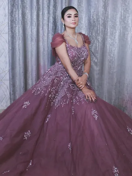 A seated portrait in the mauve-purple gown, showcasing its elegant puff sleeves and detailed neckline.