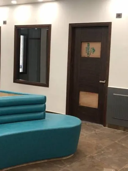The waiting area in the school reception, showing the custom sofa in relation to the surrounding architecture. The fluted pillar and dark grey wainscoting add layers of texture and visual interest.