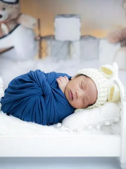 Sweet dreams for this little one, surrounded by fluffy teddy bears. This classic setup creates a timeless and heartwarming newborn photograph.