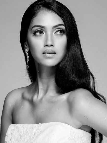 A classic black and white bridal beauty shot. The monochrome style adds a timeless elegance, focusing on the model's expression and the subtle sparkle on her skin.