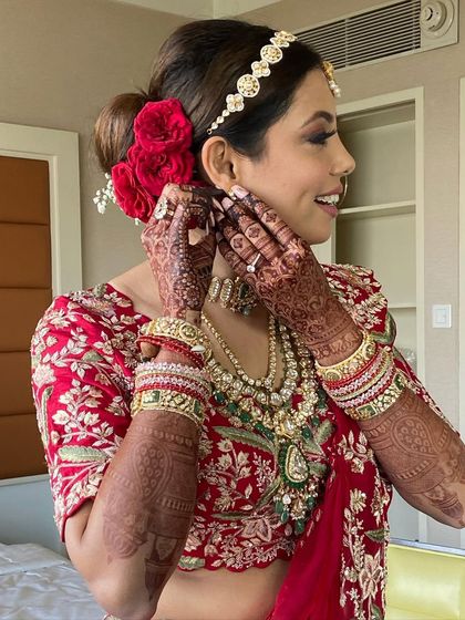 The perfect placement of red roses in this bridal bun adds a touch of romance and tradition.